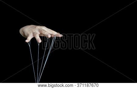 The Female Hand Controls The Doll With The Fingers, Using White Threads Attached To The Fingers On A