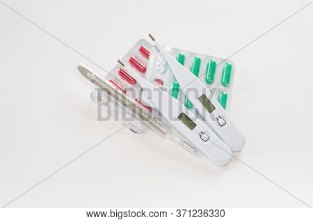 One Mercury And Two Digital Thermometers And Color Pills