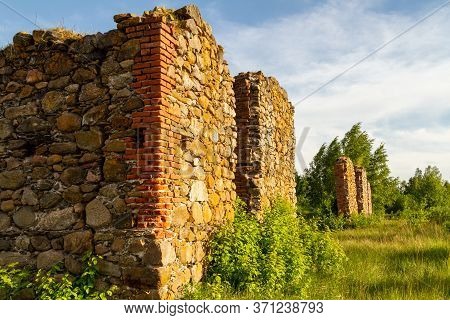 Stone Wall Ruins From A Large Building Grown In Grass In Trees