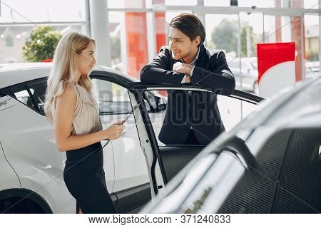 Stylish And Elegant Couple In A Car Salon