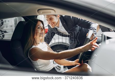 Stylish And Elegant Couple In A Car Salon
