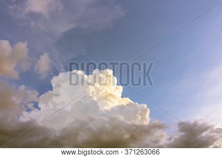 Brown Fum Clouds With Bright Light On Fluffy Clouds In Blue Sky