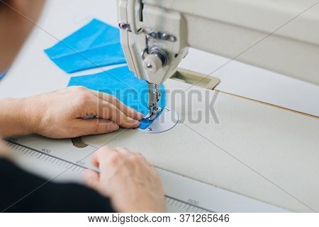 Stepwise Stitching Of Blue Fabric Medical Masks On A Sewing Machine. A Close Up Of An Industrial Sew