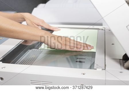 Woman Hand Putting A Sheet Of Paper Into A Copying Device