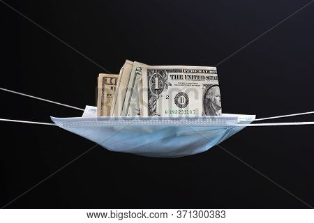 Medical Face Mask And Money On A Black Background. World Coronavirus Epidemic And Economic Losses Co