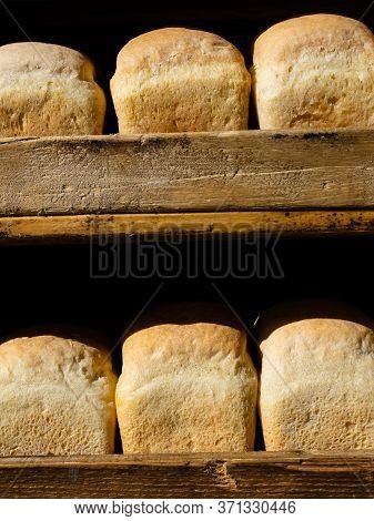 White Bread In The Shape Of A Brick On A Wooden Shelf. Fresh Bread On The Counter Of A Store Or Mark