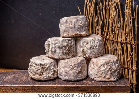 French Cheese Crottin De Chavignol In The Dark Background. High Quality Photo
