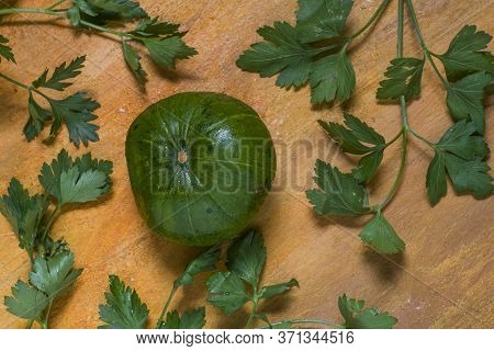 An Argentinian Pumpkin With Parsley On A Rustic Yellow Table