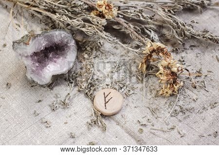 Scandinavian Wooden Rune Fehu On A Homespun Linen Cloth