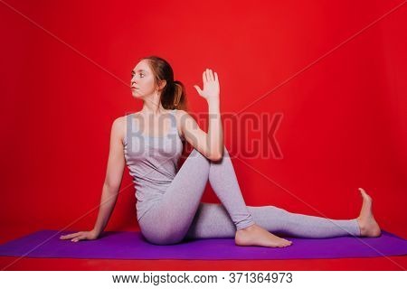 Athletic Yoga, Beautiful Young Girl Practicing Marichiasana Pose. Woman In Black Sportswear On A Sim