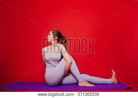 Athletic Yoga, Beautiful Young Girl Practicing Marichiasana Pose. Woman In Black Sportswear On A Sim