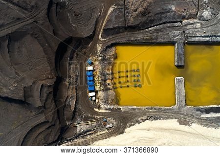 Top View On A Pool With Yellow Liquid Used In A Coal Mining In A Quarry. Heavy Industry Concept