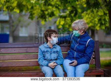 Quarantine Covid-19, Pandemic Coronavirus 2020. Boy 10 Years Old Outdoors Is Sitting On A Park Bench