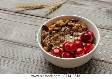 Bowl Of Oat Granola With Freshberries And Nuts On White Wooden Board For Healthy Breakfast