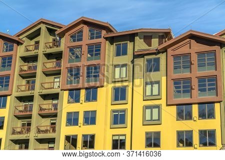 Residential Building With Multi Color Wall And Small Balconies Against Blue Sky