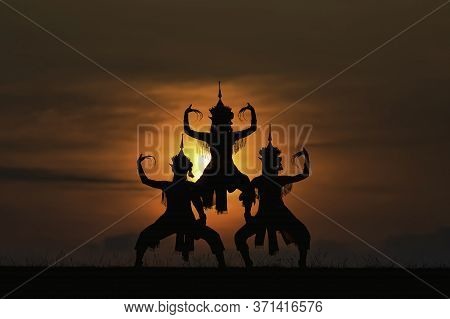 The Black Silhouette Of Three Manohra Actors Dancing In The Park In The Evening.