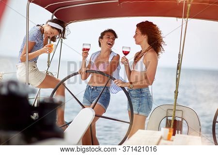 Smiling friends at theboat drinking cocktails having fun on summer vacation