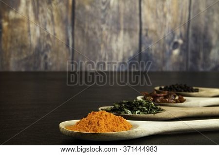 Four Wooden Spoons In Line With Assorted Spices