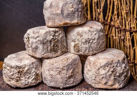 French Cheese Crottin De Chavignol In The Dark Background. High Quality Photo