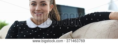 Beautiful Girl Posing While Sitting Sofa Apartment. Girl Fully Enjoys Loneliness. Learns To Notice A