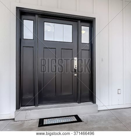 Square Frame Home Entrance With Front Porch And Black Front Door Against White Panelled Wall