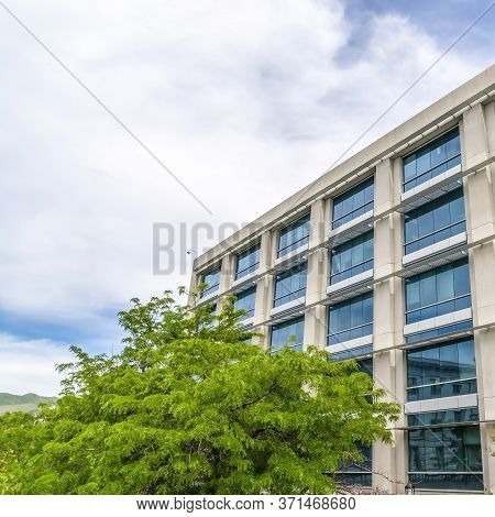 Square Exterior Of Multi Storey Commer Building With Blue Sky And Clouds Backgorund