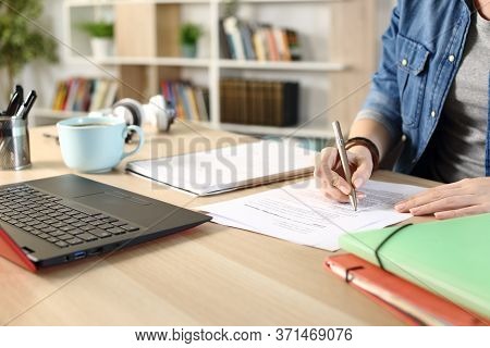 Close Up Of Student Girl Hands Doing Multiple Choice Exam On A Desk At Home