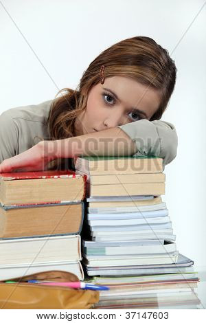 若い女性の書籍のスタック上の彼女の頭を敷設