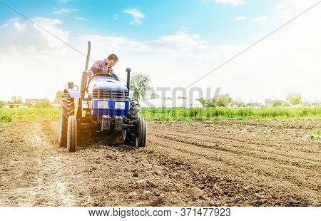 Farmer Is Processing Soil On A Tractor. Soil Milling, Crumbling Mixing. Loosening Surface, Cultivati