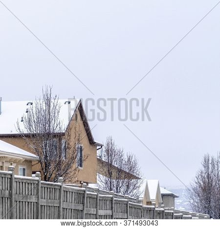 Square Crop Snowy Houses On A Scenic Suburb Neighborhood Against Cloudy Sky In Winter