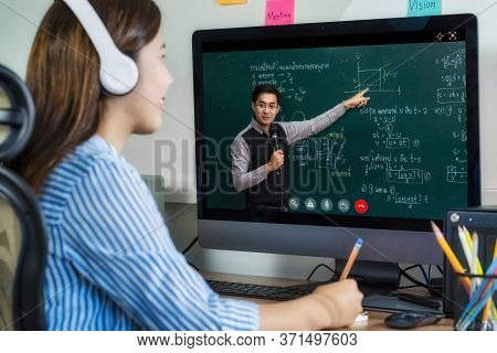 Rear View Of Asian Student Learning With Teacher Over The Physics Formular In Thai Laguage On Black 