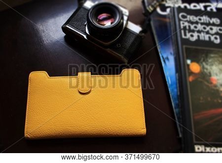 Mumbai, India - Circa 2015: Yellow Purse With Old Camera And Some Photography Magazines. Woman Photo