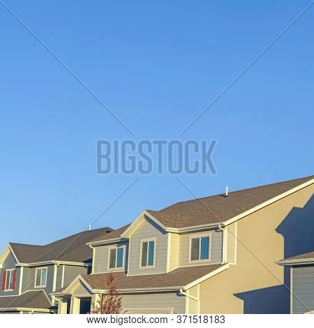Square Frame Homes With Horizontal Wall Sidings And Front Gable Roofs Againts Clear Blue Sky