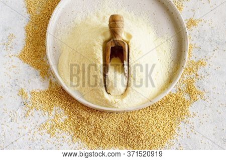 Plate Of Raw Amaranth Flour With A Scoop And Amaranth Seed On White Table Top View