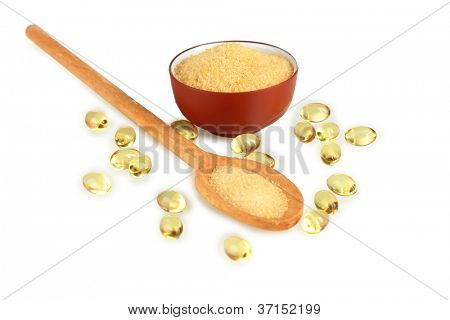 Gelatin in a bowl and wooden spoon on white background close-up
