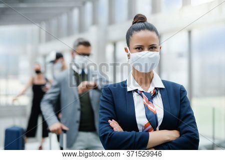 Portrait Of Flight Attendant Standing On Airport, Wearing Face Masks.