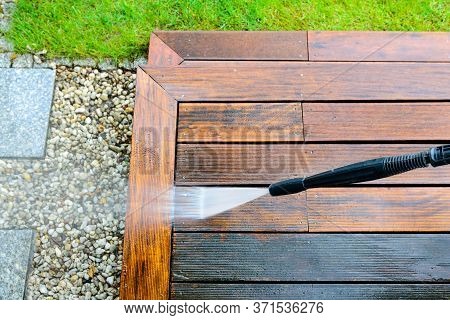 Cleaning Terrace With A Power Washer - High Water Pressure Cleaner On Wooden Terrace Surface - Focus
