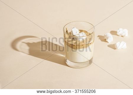 Dalgon Coffee In A Transparent Glass With Milk On A Pastel Background With Marshmallows.