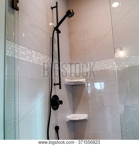 Square Black Round Shower Head On Tile Wall Of Shower Stall With Hinged Glass Door