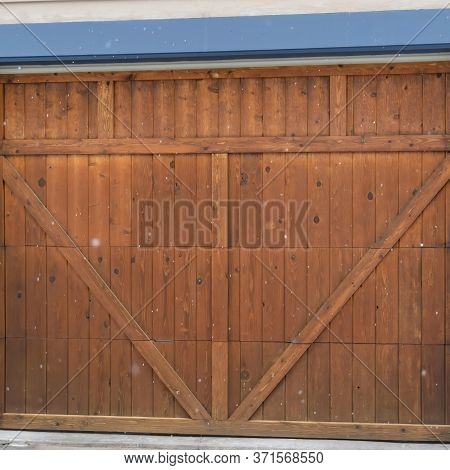 Square Crop Brown Wood Garage Door With Blue Frame Flaned By Wall Mounted Vintage Lanterns