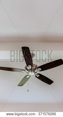 Vertical Crop Ceiling Fan With Wood Blades And Built In Lights On The Ceiling Beam Of Home