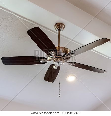 Square Decorative Wood Beam With Standard Ceiling Fan And Lights Inside A House