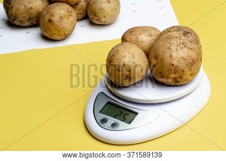 Potatoes Are Weighed On A White Scale In The Background Potatoes And A Sheet Of Paper With Dates. Po