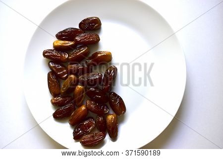 Ripe And Delicious Dates On A White Plate