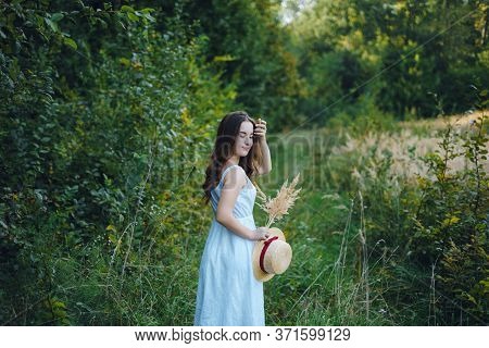 Beautiful Girl In A White Dress With A Bouquet Of Dried Flowers. Young Woman In A Green Park. Girl I