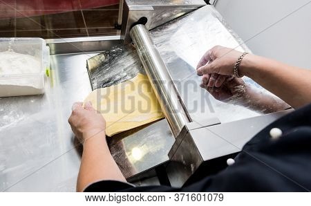 Chef Rolling Dough With A Pasta Machine. Pasta Maker Machine.