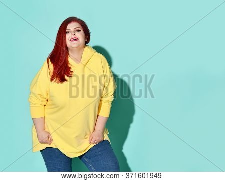 Smiling Pluse-size Lady In Sunny Yellow Sweatshirt Standing Uninhibitedly Looking At Camera. Active 