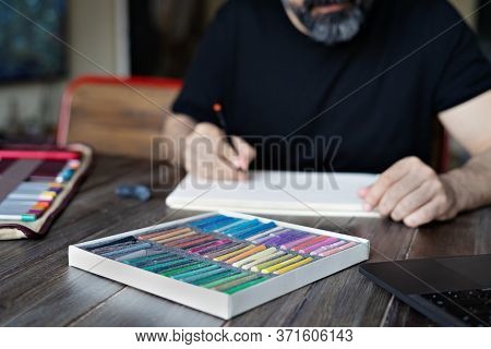 Person Learning Online Painting With Pensil And Pastel Crayon On White Sheet Of Paper In Front Of La