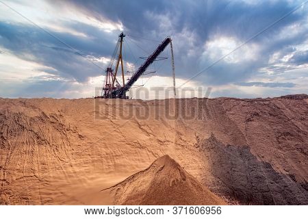Industrial Background. Salt Mining Site Under A Sky With Dramatic Clouds. Large Excavator Machine An