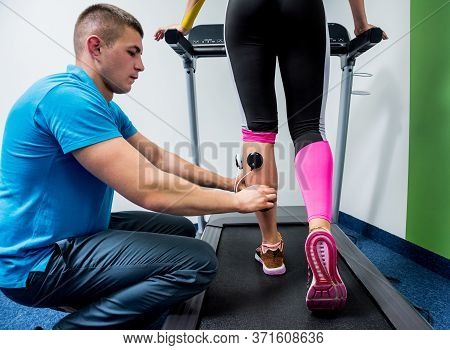 Physical Therapist Install Electrostimulator On The Muscles Of The Legs